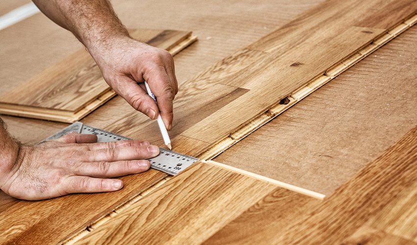 A craftsman lays oak parquet with a click system.