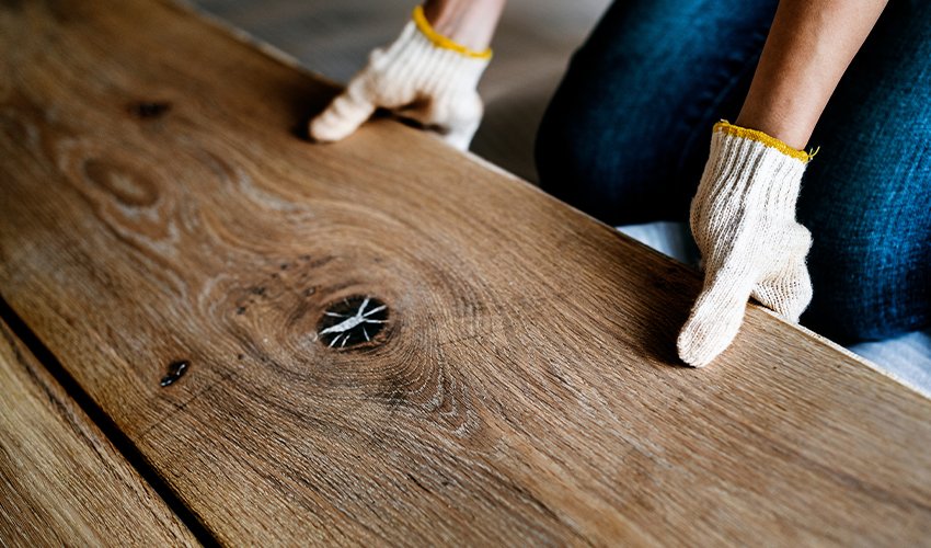 Carpenter man installing wooden floor.